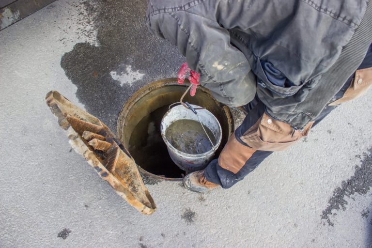  Technician unclogging a large outdoor drain.